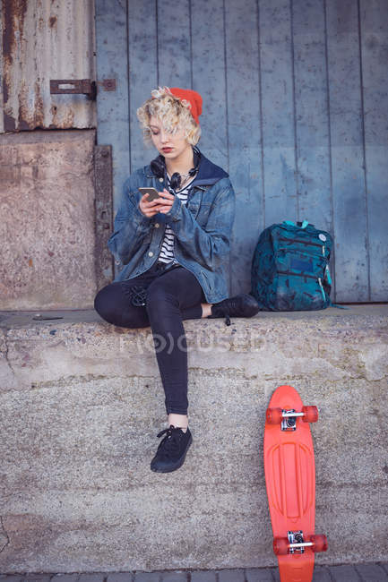 Mujer usando teléfono móvil cerca del sendero en la ciudad - foto de stock