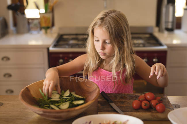 Menina preparando comida na cozinha em casa, cozinhando salada com pepinos e tomates — Fotografia de Stock