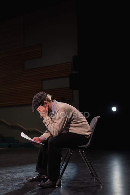 Männlicher Schauspieler liest Drehbuch auf der Bühne im Theater — Stockfoto