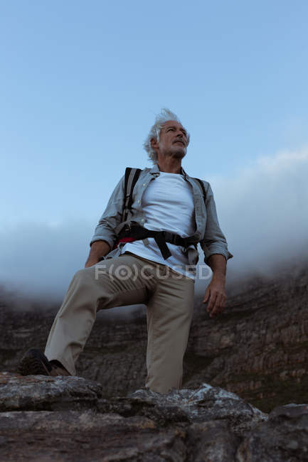 Caminhante sênior em pé no topo da montanha no campo — Fotografia de Stock