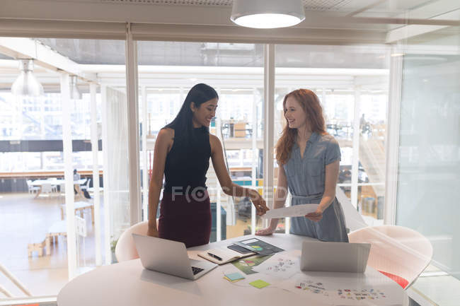 Жінки-керівниці обговорюють документ в офісі — стокове фото