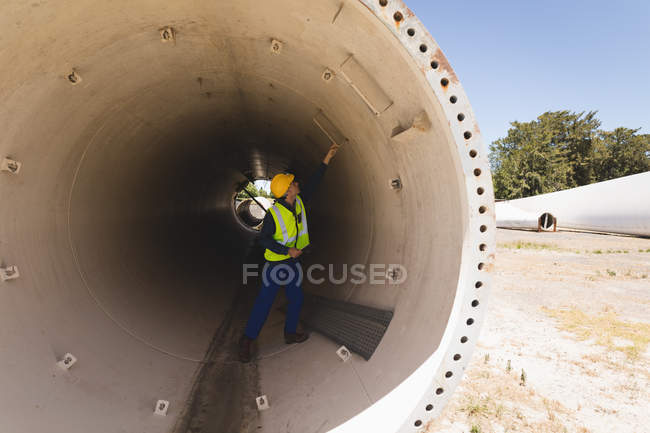 Рабочий мужчина осматривает бетонный тоннель на солнечной станции — стоковое фото