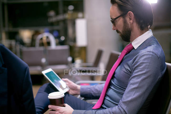 Geschäftsmann nutzt digitales Tablet im Wartebereich am Flughafen — Stockfoto