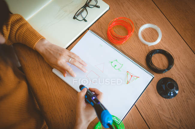 Mid section of woman drawing a sketch in a book at home — Stock Photo