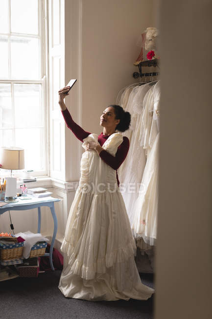 Noiva mestiça tomando selfie com telefone celular em boutique — Fotografia de Stock
