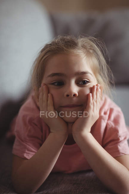 Little girl relaxing on sofa in living room at home — Stock Photo