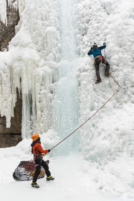 Скалолаз зимой на ледяную гору — стоковое фото