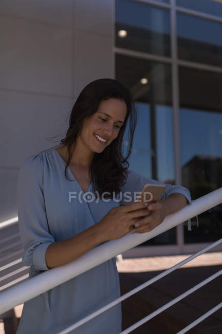 Jeune femme utilisant téléphone portable à l'extérieur — Photo de stock