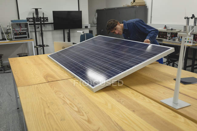 Чоловік працює на сонячній панелі в офісі — стокове фото