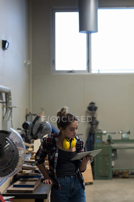Femme charpentier utilisant une tablette numérique à l'atelier — Photo de stock