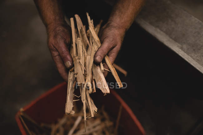 Schmied hält Holzstäbe in Werkstatt — Stockfoto