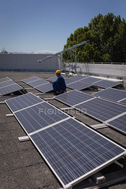 Рабочий мужчина, использующий цифровой планшет на солнечной станции в солнечный день — стоковое фото