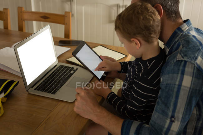 Отец со своим сыном использует цифровой планшет дома — стоковое фото