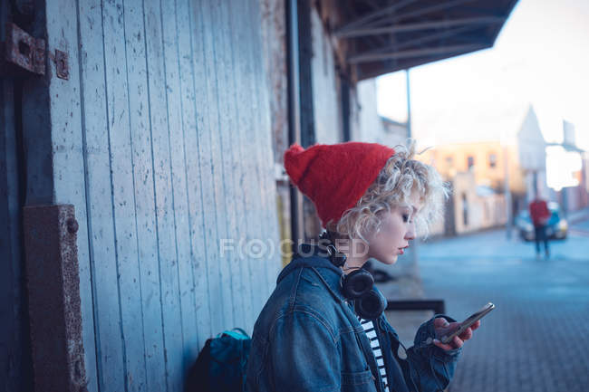Young woman using mobile phone near city street — Stock Photo