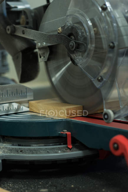 Grinder cutting machine cutting a piece of wood at workshop — Stock Photo