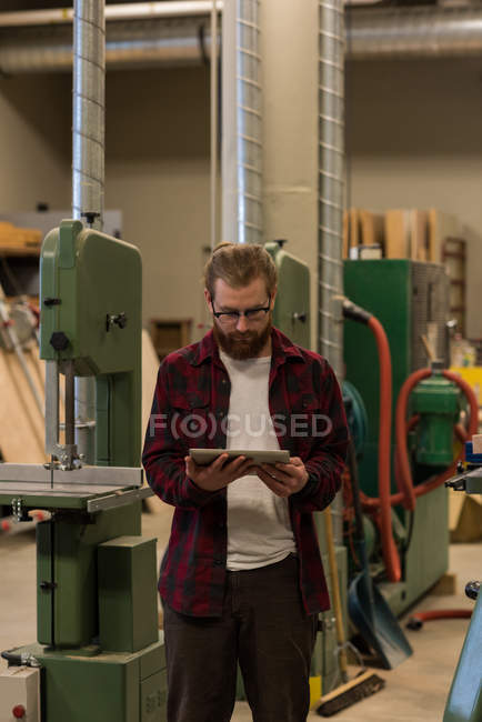 Carpinteiro masculino usando comprimido digital na oficina — Fotografia de Stock