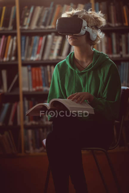 Jovem mulher usando fone de ouvido realidade virtual na biblioteca — Fotografia de Stock