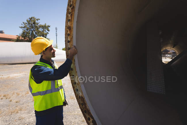 Male worker examining a concrete tunnel at solar station — Stock Photo