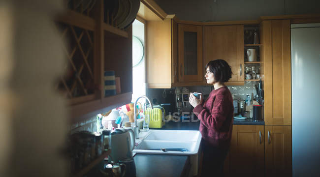 Donna premurosa che prende il caffè in cucina a casa — Foto stock