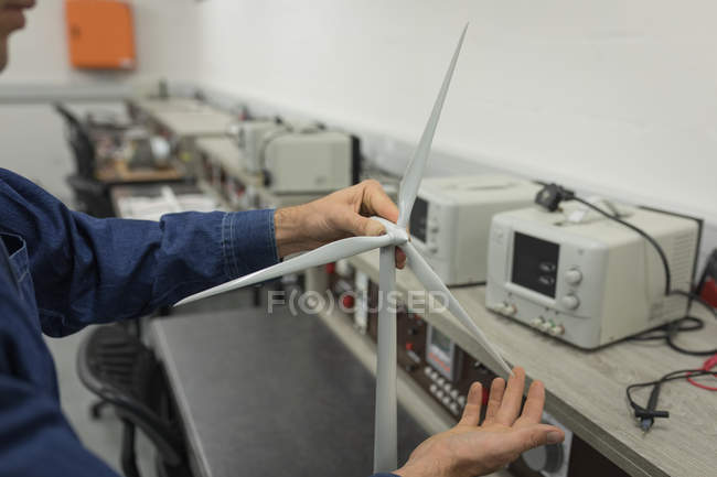 Travailleur masculin travaillant sur un moulin à vent au bureau — Photo de stock