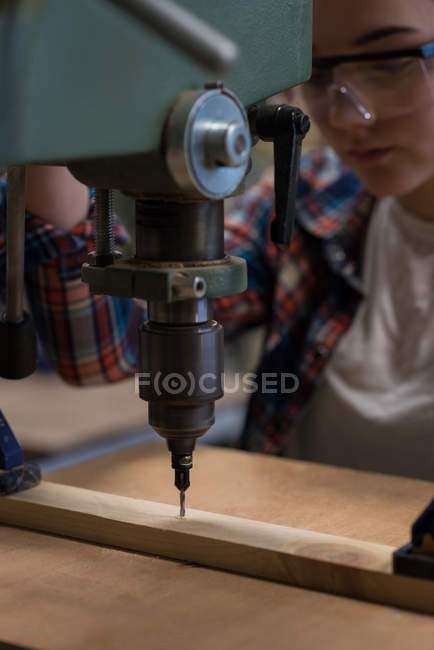 Tischlerin mit Vertikalbohrmaschine in Werkstatt — Stockfoto