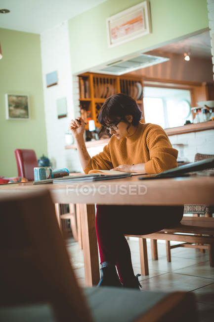 Woman drawing a sketch in a book at home — Stock Photo