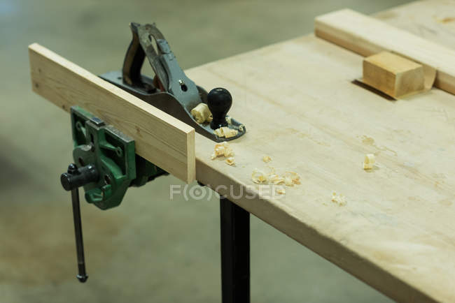 Jack plane with piece of wood on a table at workshop — Stock Photo