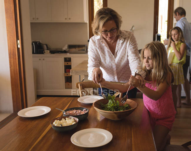 Famiglia che pranza in cucina a casa — Foto stock