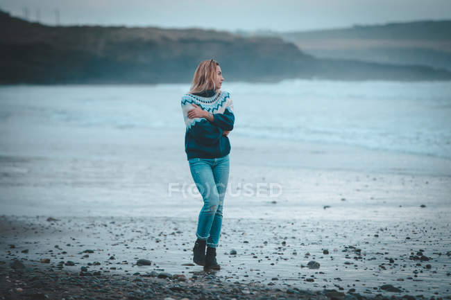 Mulher pensativa andando em uma praia — Fotografia de Stock