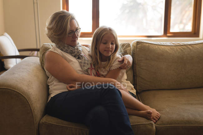 Mother and daughter sitting together in living room at home — Stock Photo