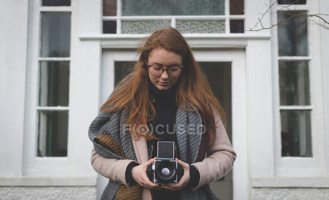 Mulher tirando foto com câmera vintage no quintal de sua casa — Fotografia de Stock