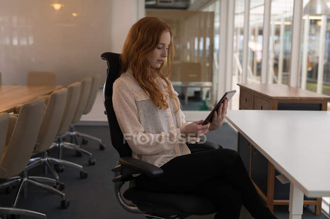 Jovem executiva usando tablet digital no escritório — Fotografia de Stock