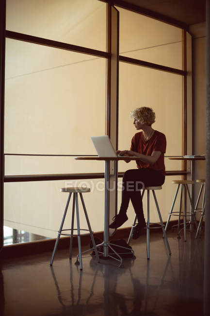 Mulher usando laptop na cafetaria na universidade — Fotografia de Stock