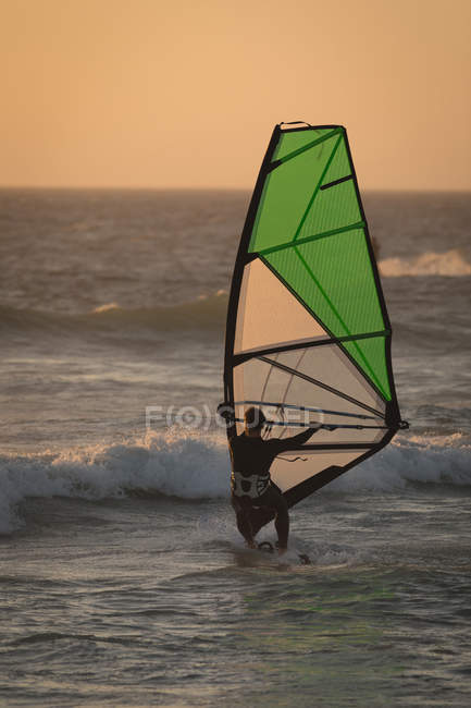 Surfista masculino surfando com prancha e pipa na praia — Fotografia de Stock
