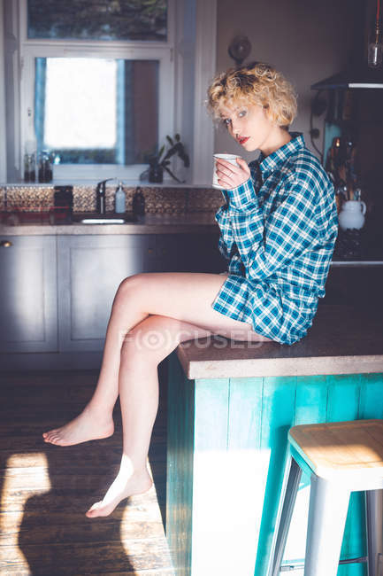 Junge Frau mit in der Küche zu Hause — Stockfoto