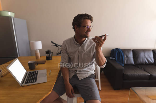 Счастливый человек разговаривает по мобильному телефону дома — стоковое фото
