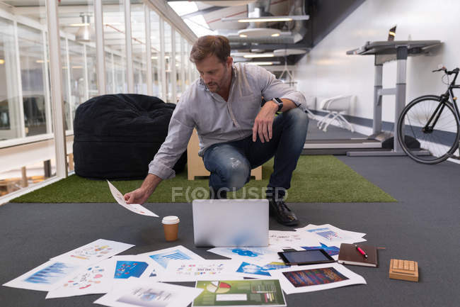 Мужчина-руководитель смотрит на документ в офисе — стоковое фото