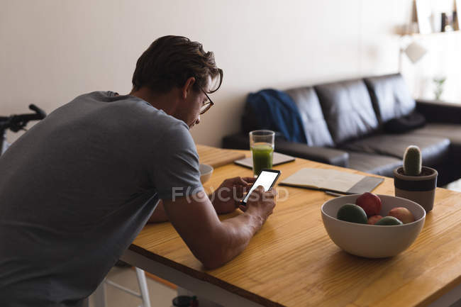 Чоловік використовує мобільний телефон у вітальні вдома — стокове фото