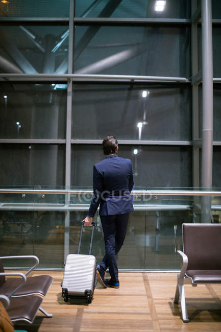 Вид ззаду бізнесмена, який чекає в зоні очікування в аеропорту — стокове фото