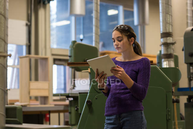 Carpinteiro feminino usando tablet digital na oficina — Fotografia de Stock