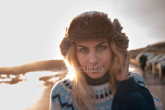 Porträt einer Frau, die in der Abenddämmerung am Strand steht — Stockfoto