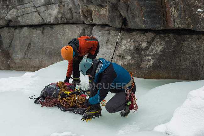 Male rock climber wearing crampons near rocky mountain during winter — Stock Photo