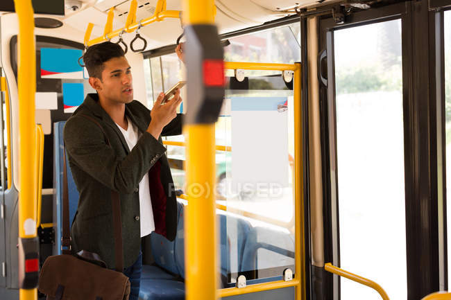 Молодий підприємець говорити на мобільний телефон під час поїздки в автобусі — стокове фото