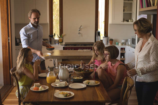 Família almoçando na cozinha em casa — Fotografia de Stock