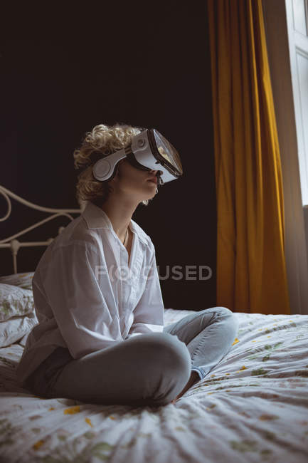 Frau benutzt Virtual-Reality-Headset im Schlafzimmer zu Hause — Stockfoto