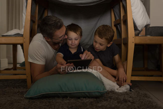 Father with his sons using digital tablet at home — Stock Photo