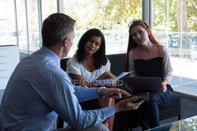 Des collègues d'affaires discutent sur tablette numérique au bureau — Photo de stock
