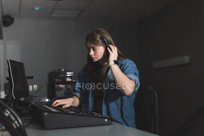 Young female sound recordist working in theater — Stock Photo