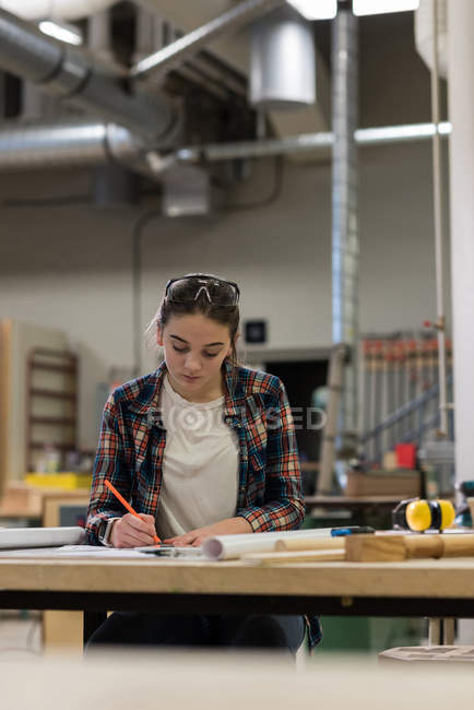 Jovem carpinteiro do sexo feminino trabalhando na oficina — Fotografia de Stock