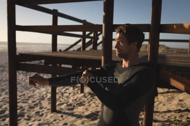 Thoughtful male surfer wearing swimsuit on the beach — Stock Photo